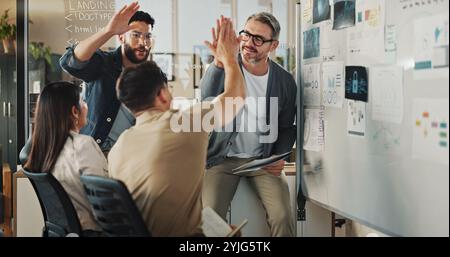 Teamwork, high five and brainstorming with business people in meeting for coding workshop, cyber security and success. Collaboration, support and Stock Photo