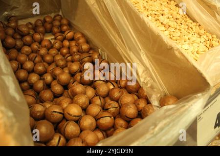 Macadamia nut in a box at the store. Availability of nuts. Benefits and harms of nuts. Stock Photo