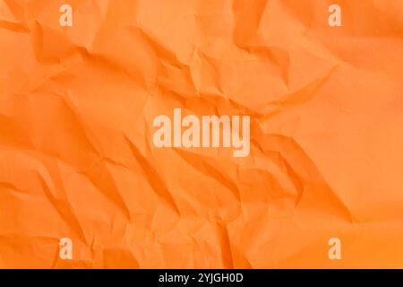 Top view and full frame of wrinkled or crumpled orange paper is used as crumpled orange paper background texture. Stock Photo