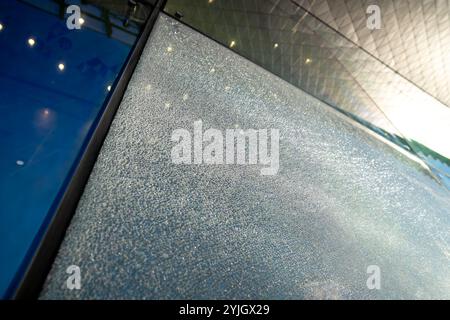 Shattered facade glass panel with visible cracks, no falling. Smart glass technology, damage control Stock Photo