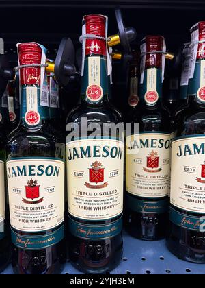 Kyiv, Ukraine - November 14, 2024: Close-up of Jameson Irish whiskey bottles lined up on a store shelf, showcasing the iconic label and red caps. Perf Stock Photo