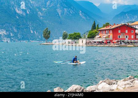 RIVA DEL GARDA, ITALY – AUGUST 21, 2024: Riva del Garda, a scenic town on Lake Garda's northern shore, offers breathtaking mountain views and clear bl Stock Photo