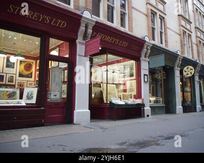 Shops with colourful vintage Victorian facades in Cecil Court, also known as new bookseller's row selling art and maps in Covent Garden, London, U.K. Stock Photo