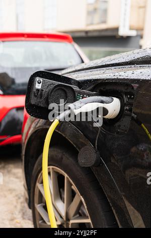 Black wet electric car plug closeup Stock Photo
