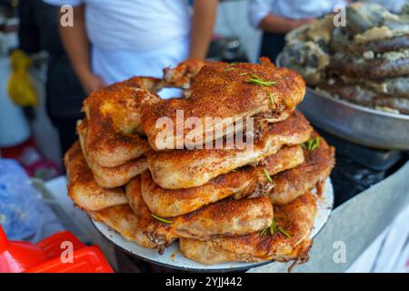 A pile of chicken is covered in spices and sits on a white plate Stock Photo