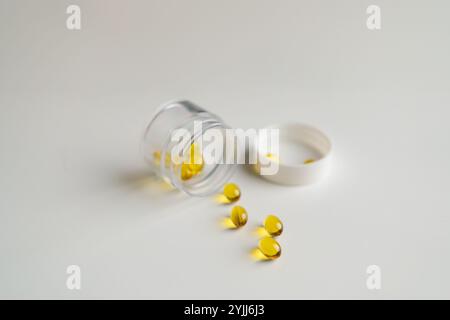 Open pill bottle with capsules on white background Stock Photo
