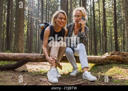 Woman dislocates ankle stepping over log on forest strolling Stock Photo