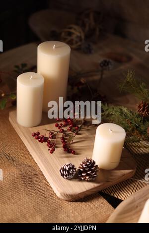 Autumn-themed Christmas decorations with candles, warm tones, fall foliage, and rustic, cozy holiday charm. Stock Photo