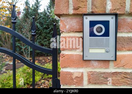 Modern gate intercom with camera on brick wall Stock Photo