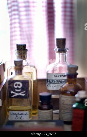 old vintage medicine bottles on panty shelf in old cottage norfolk england Stock Photo