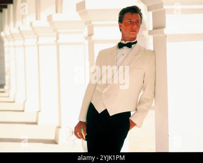 Spain. Marbella. Young man in tuxedo standing under building cloisters. Stock Photo