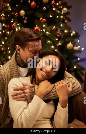 A couple shares laughter and warmth while celebrating Christmas in their beautifully decorated home. Stock Photo