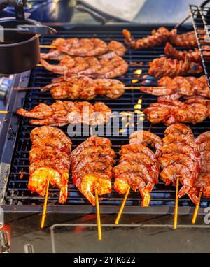 prawns on a barbeque grill cooking on skewers Stock Photo