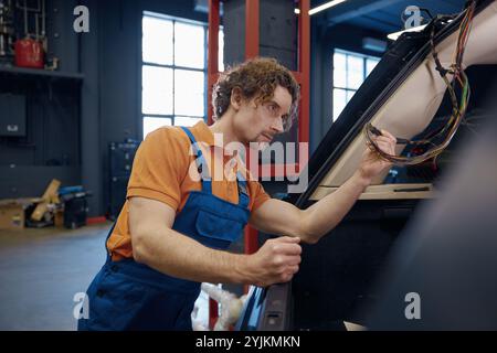 Male auto electric checking car cables and electrical system Stock Photo