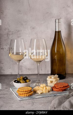 Food photography of white wine with goat gouda cheese, parmesan, olives, crackers, french meal, winery, assortment, snack for couple Stock Photo