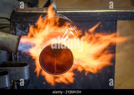 Glassblowing - using a blowtorch to work on a blown glass vase (UK) Stock Photo