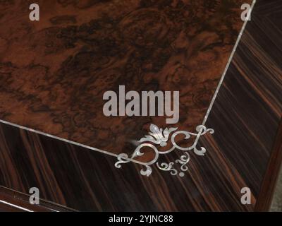 Texture of a flower-shaped inlay, on a wooden table top Stock Photo