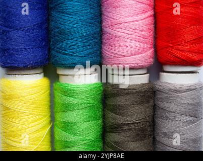 A detailed view of multicolored threads, featuring vibrant tones of blue, pink, red, green, and yellow. Stock Photo