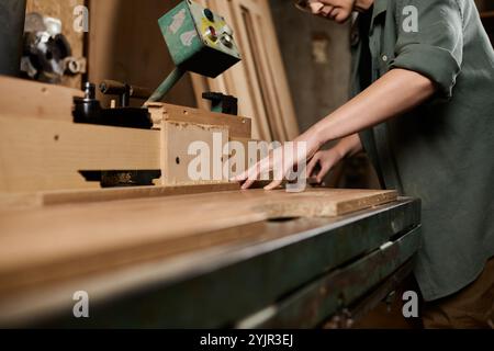 Craftswoman meticulously working with wood in a vibrant workshop, embodying skill and passion for carpentry. Stock Photo