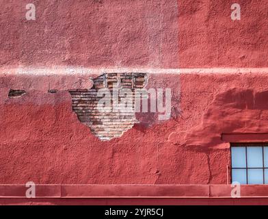 Building shedding stucco over brick Stock Photo