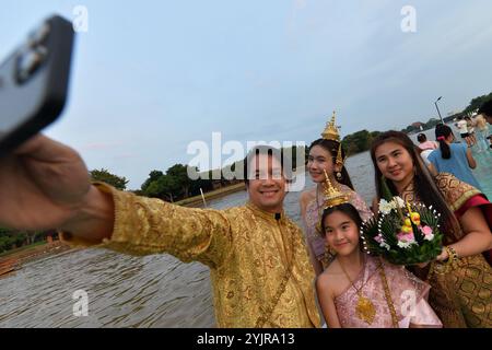 Ayutthaya, Thailand. 15th Nov, 2024. People take selfies with a water lantern during the Loy Krathong Festival by the Chao Phraya River in Ayutthaya, Thailand, Nov. 15, 2024. Credit: Rachen Sageamsak/Xinhua/Alamy Live News Stock Photo