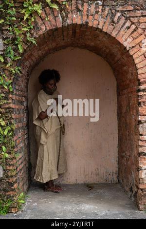 Black woman chained and with an iron mask on her face leaning against a brick wall. Representation of the slave Anastacia. Slavery in Brazil. Stock Photo