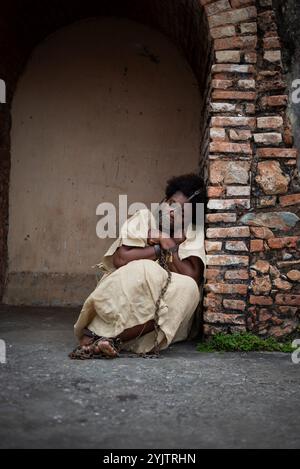 Black woman with an iron mask on her mouth and chained, sitting on the floor of Pelourinho. Slavery in Brazil. Representing the slave Anastacia. Stock Photo