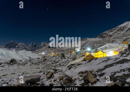 Night time sky over Everest base camp on Khumbu glacier. Tents are lit with lights from inside. Nepal. Stock Photo