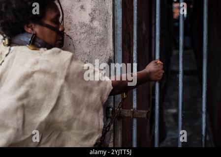 Black woman dressed as a slave, chained with an iron mask on her mouth, holding an iron fence. Slavery in Brazil. Representation of the slave Anastaci Stock Photo