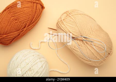 Different yarns, knitting needles on purple background. Autumn. Stock Photo