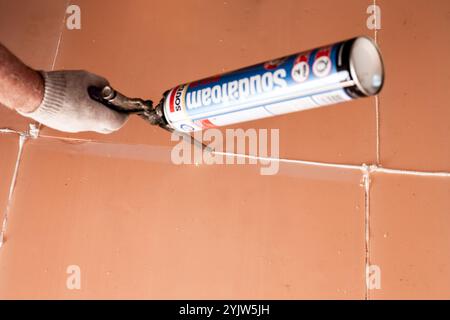 Using construction foam to seal seams. Laying polyurethane foam on the floor. Russia, Anapa-07.06.2024 Stock Photo