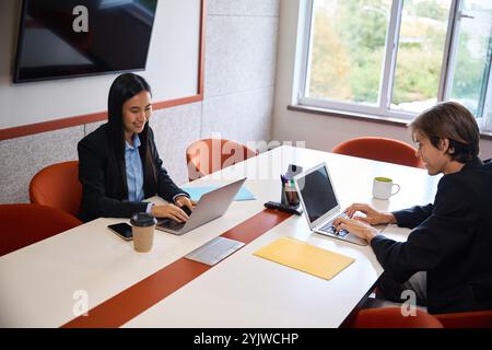 Guy and a young woman are working in a meeting room Stock Photo