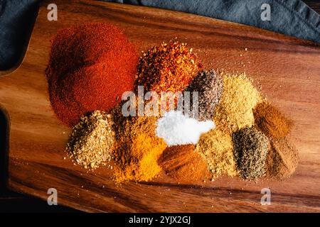 Berbere Spice Blend Ingredients on Cutting Board Close-up: Ground herbs and spices for Ethiopian Berbere spice mixture on a wooden chopping board Stock Photo