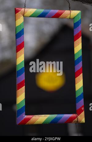 multi coloured striped rectangular painted wooden frame with yellow red blue purple and green primary colors in stripes empty framed blank space insid Stock Photo