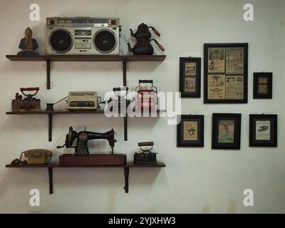 A collection of ancient tools from the past displayed on the wall of a coffee shop in Chinatown Stock Photo