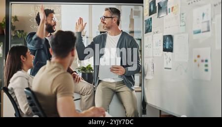 Mentor, high five and brainstorming with business people in meeting for coding workshop, cyber security and success. Collaboration, support and Stock Photo