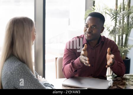 Handsome young African American businessman in casual talking to colleague Stock Photo