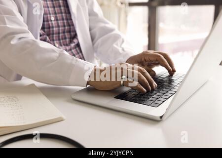 Close up cropped view of male doctor using laptop Stock Photo