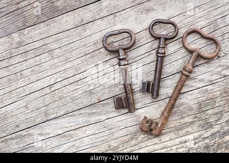 Old vintage rusty keys keys on wooden table. Escape room game background. Stock Photo
