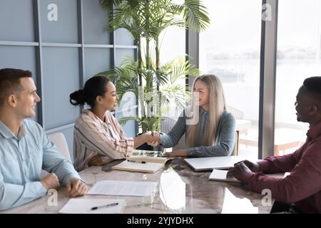 Cheerful female business leader shaking hands with female African colleague Stock Photo