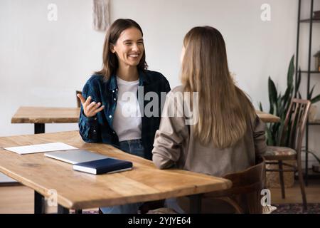 Two colleagues leading positive conversation during meeting in office Stock Photo