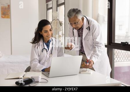Two doctors colleagues using laptop at workplace Stock Photo