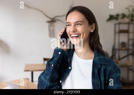 Young woman talking on smartphone at workplace Stock Photo