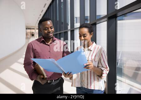 Couple of young African American coworkers discussing project documents Stock Photo