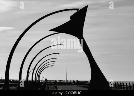 Whale Tail sculpture (wind shelter) on Blackpool South promenade with curved modern lights and backlit by sun. Blackpool UK Stock Photo