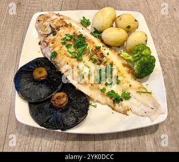 Delicious freshly caught grilled Dover Sole with new potatoes flat mushrooms broccoli garlic butter and parsley Stock Photo