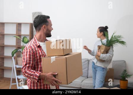 young couple carries cardboard boxes after relocating abroad, happiness and new beginnings Stock Photo