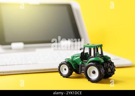 Rental Agricultural Machinery. Farm Software. Concept of using modern technologies and artificial intelligence in agriculture. Tractor and gadget on y Stock Photo