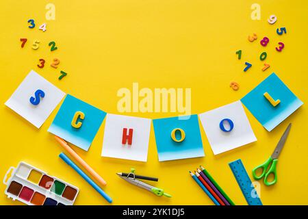Back to school concept. colorful letters School. school supplies on a yellow background, copy space. Flat lay of kindergarten or school supplies. Stock Photo