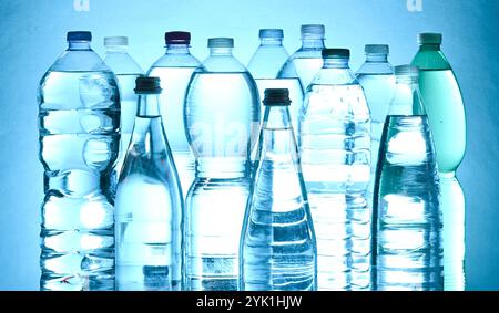 plastic mineral water bottles photographed against the light on a blue background Stock Photo